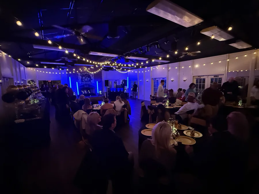 Guests celebrating a milestone birthday under string lights
