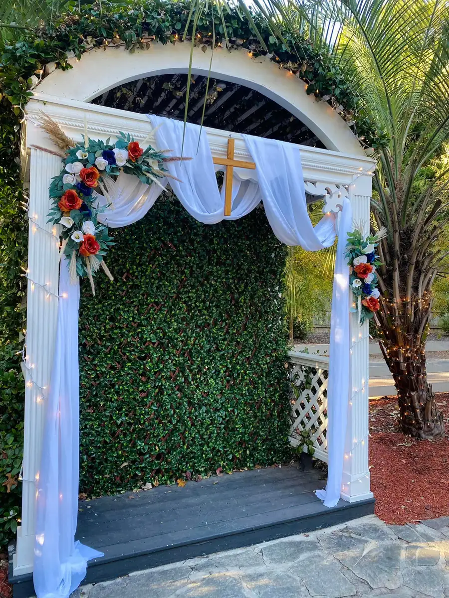 Ceremony arch with white draping and flowers