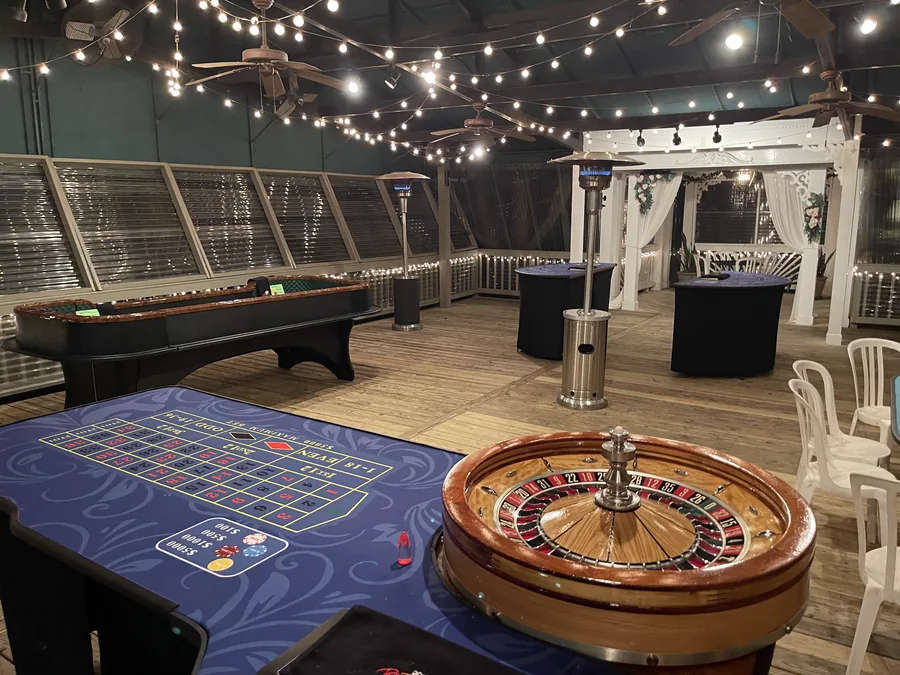 Casino night roulette table under string lights on the veranda at Wintergreen Woods