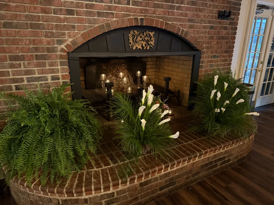 Fireplace dressed with ferns and calla lilies