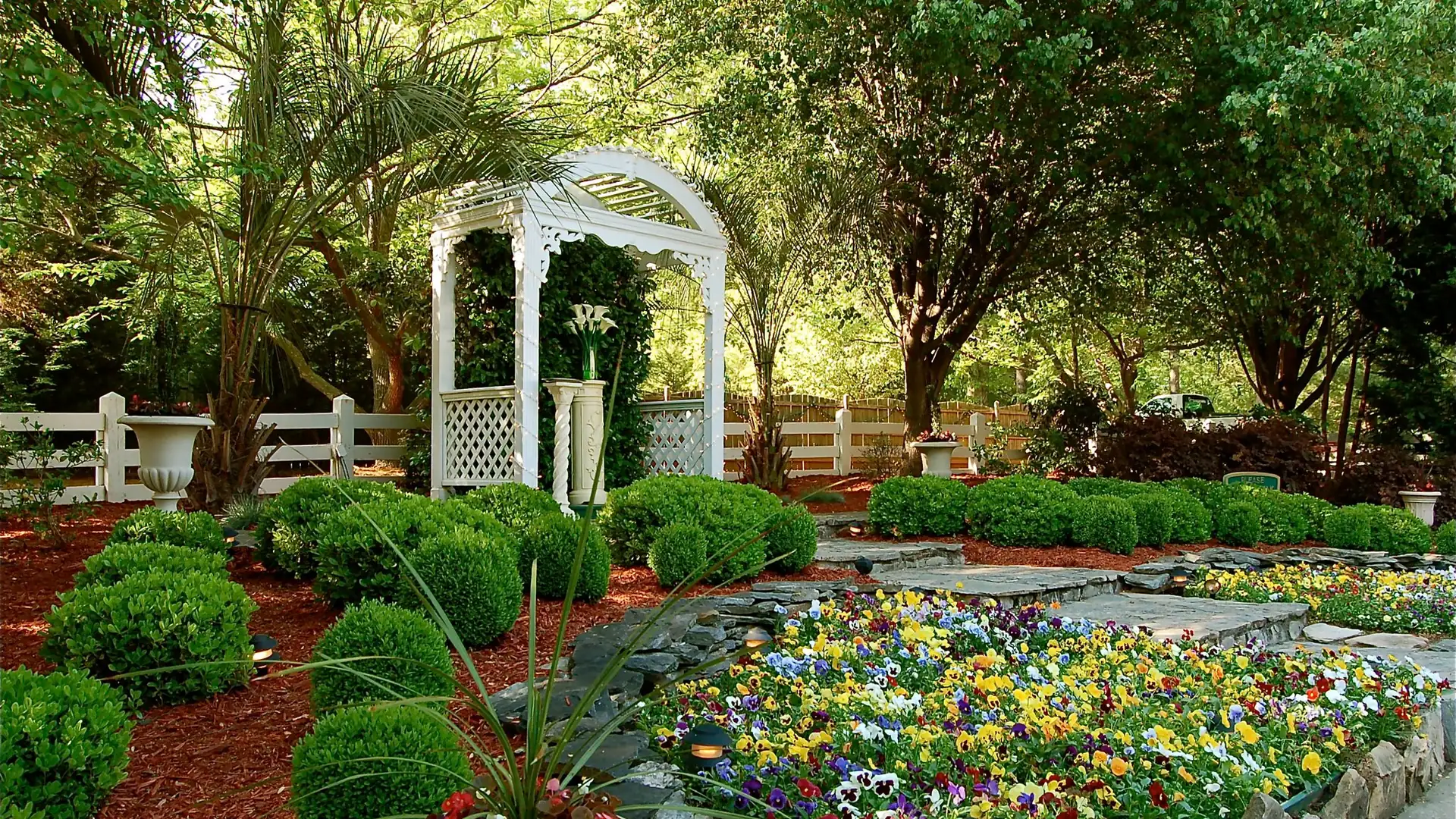 Garden arbor surrounded by flower beds