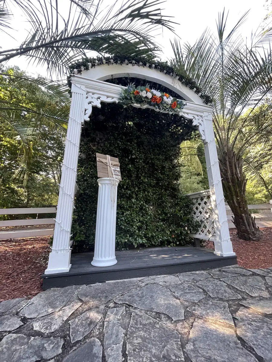 The columned garden arch against the greenery wall
