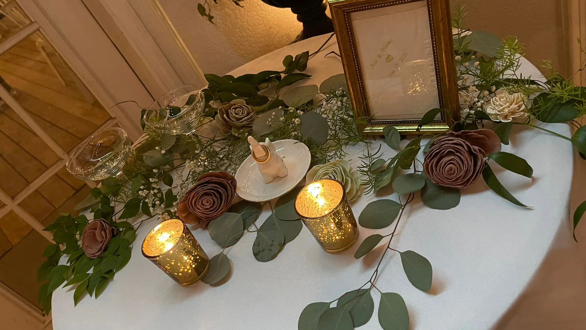 Head table dressed with greenery and candles