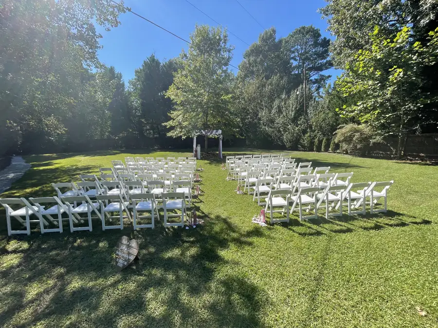 The ceremony lawn set with white chairs under a blue sky