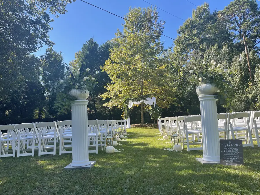 Lawn ceremony setting with columns and greenery