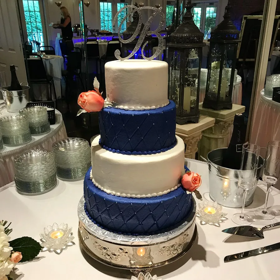 Wedding cake with navy ribbon and peach roses