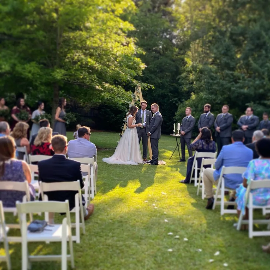 Guests seated for an outdoor wedding ceremony in golden evening light