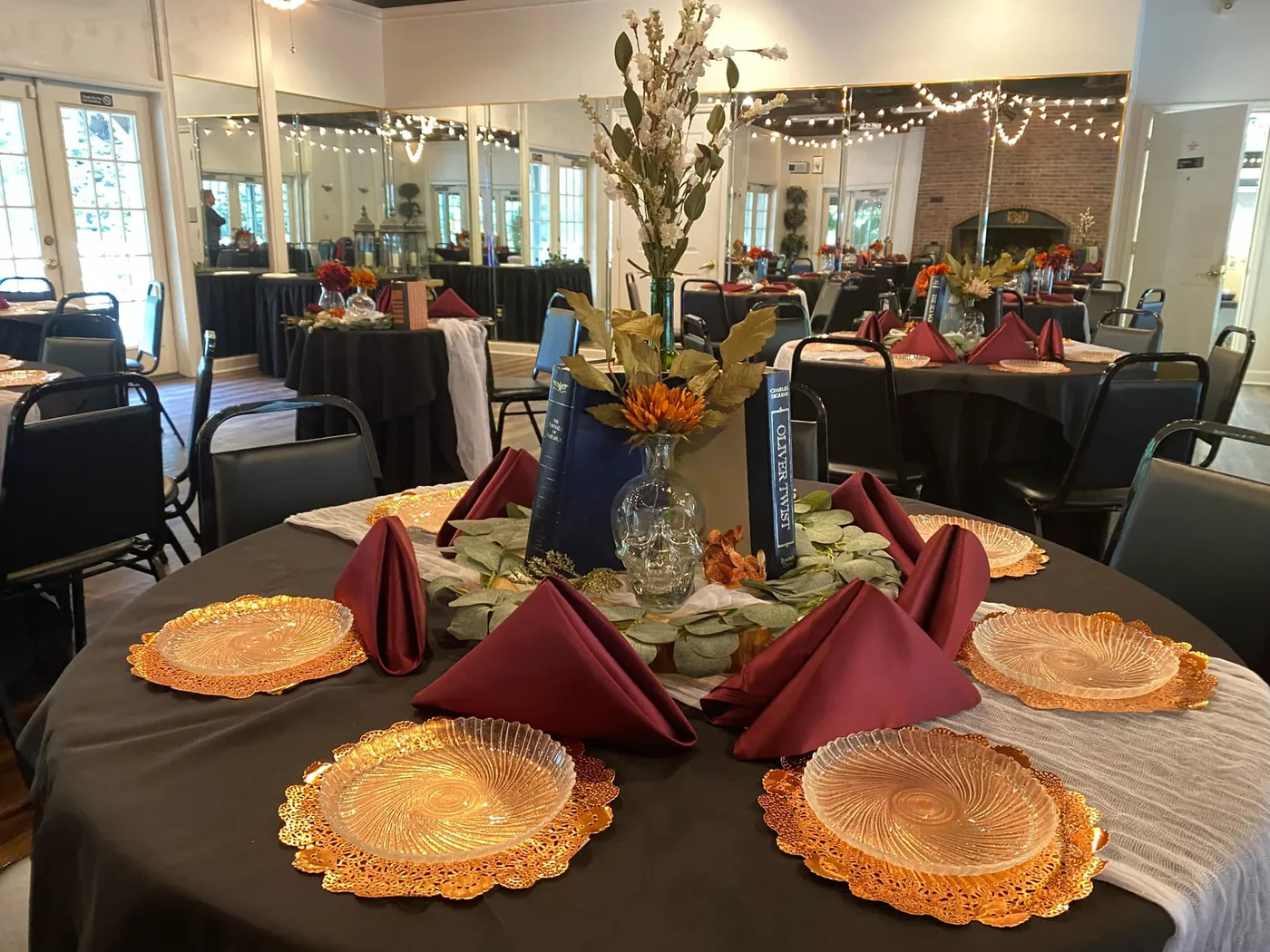 Place setting with gold chargers and burgundy napkins