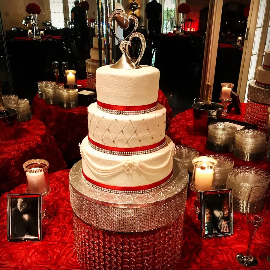 Tiered wedding cake finished with a red ribbon