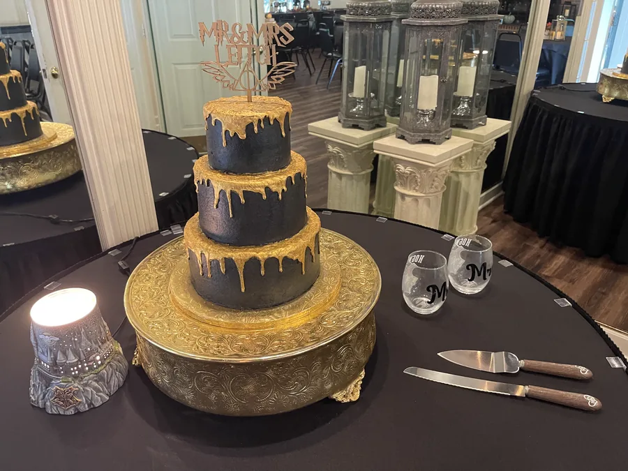 Black and gold drip cake at a themed celebration