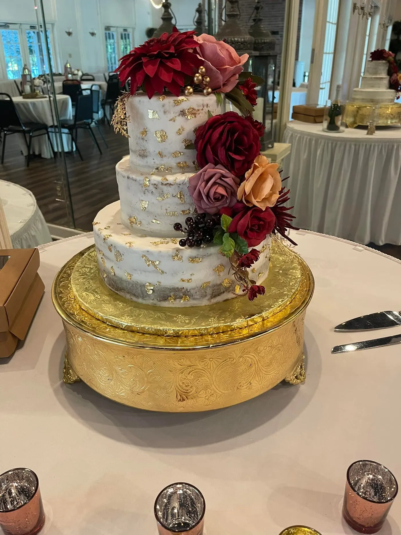 Tiered wedding cake with burgundy roses